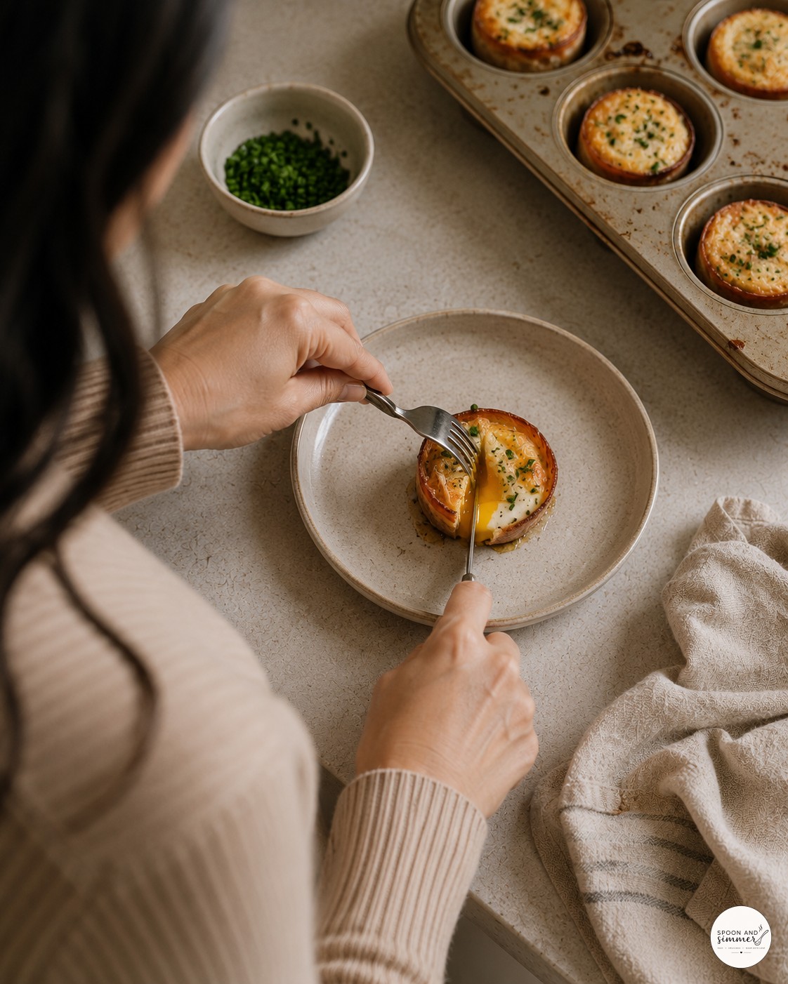 Slicing into a baked French egg on a plate to check the soft yolk center