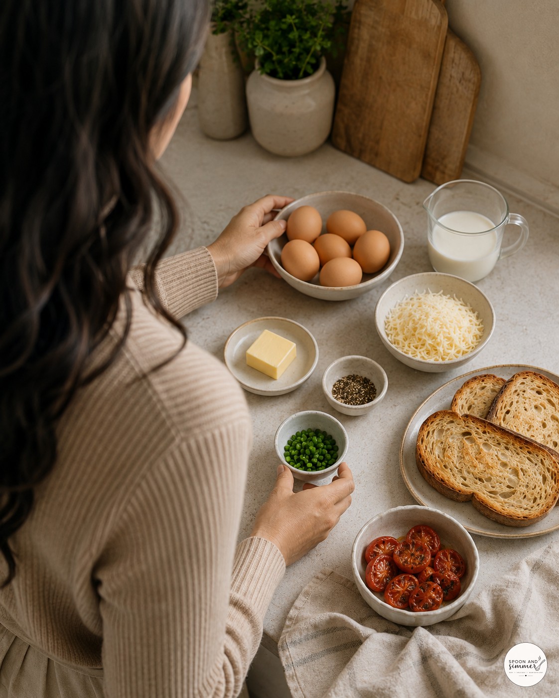 Woman arranging eggs, cream, butter, and toast on a kitchen counter for baked French eggs