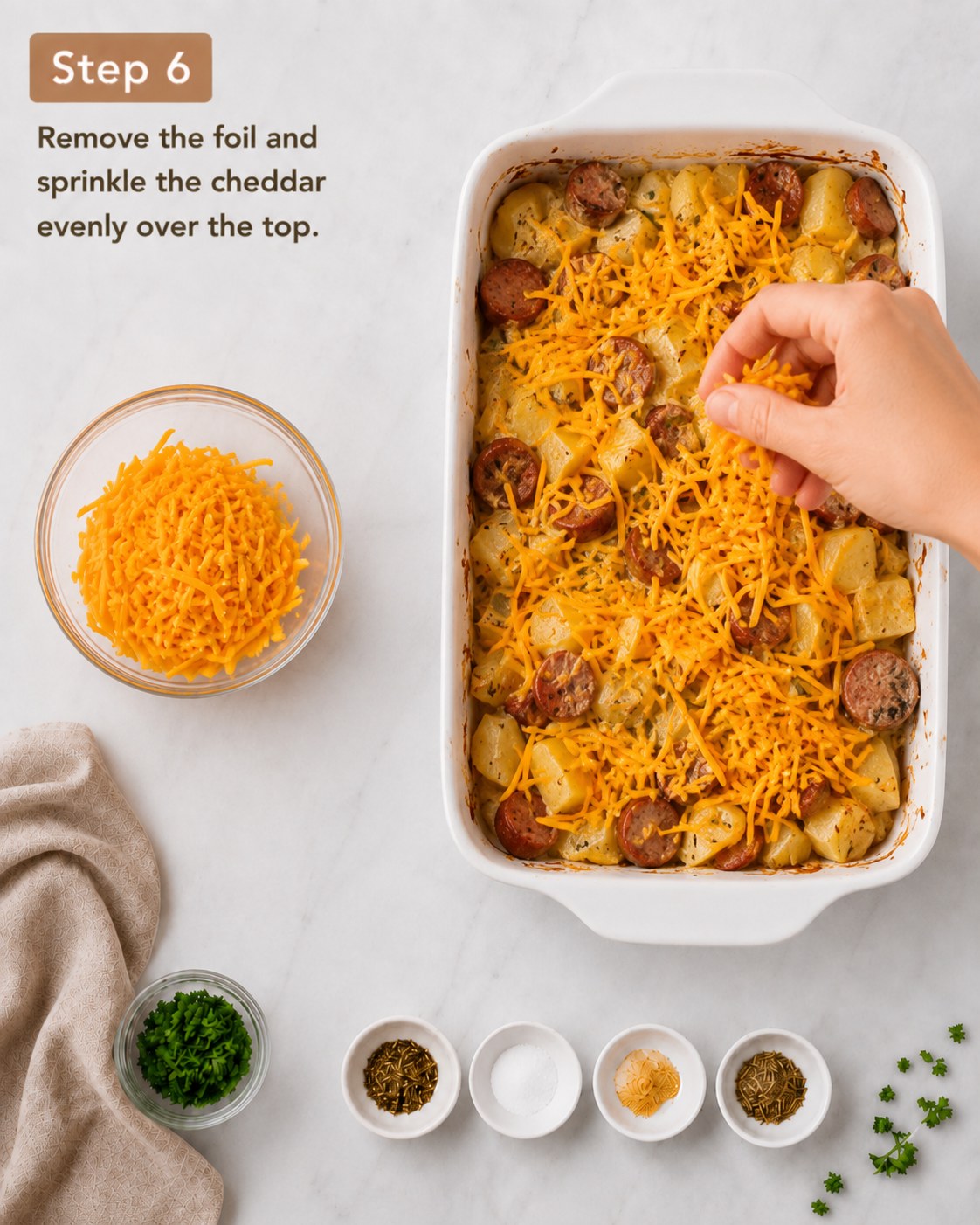 Shredded cheddar sprinkled over the baked cheesy potato sausage casserole before its final bake