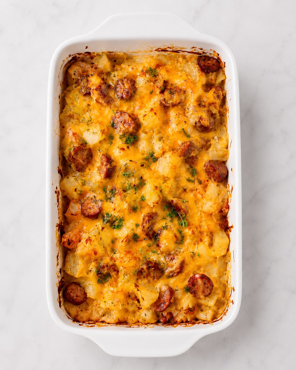 Finished cheesy potato sausage casserole fresh out of the oven with crisped sausage edges