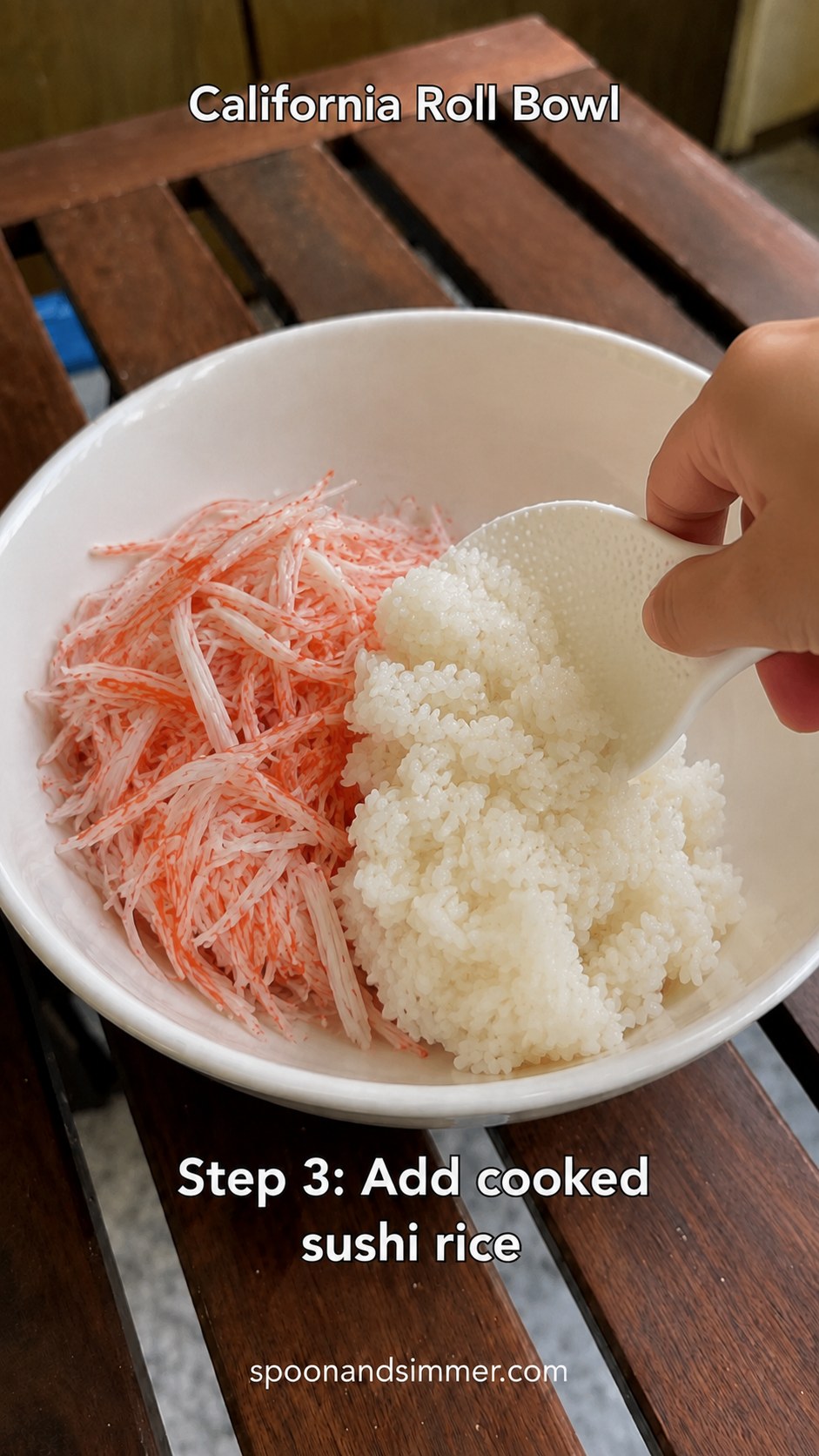 Adding a scoop of seasoned sushi rice beside shredded crab in a bowl