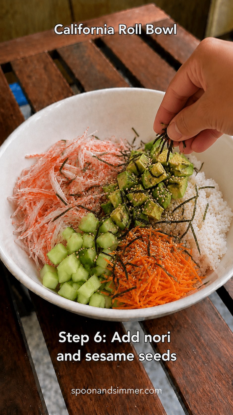 Crumbled nori and toasted sesame seeds sprinkled over a California roll bowl