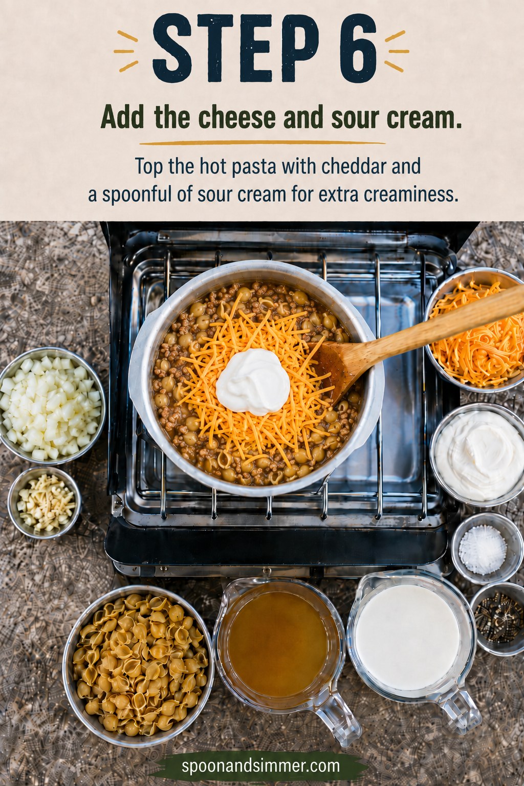Shredded cheddar and a scoop of sour cream added to hot one pot camping hamburger helper