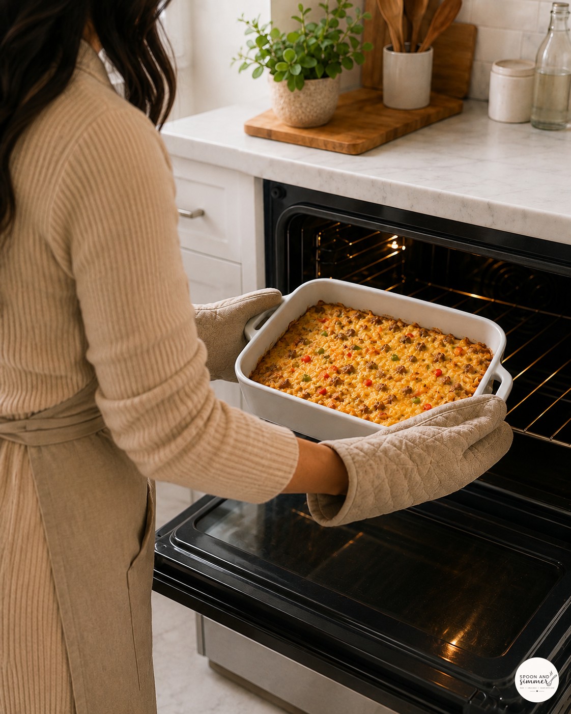 Placing sausage hash brown breakfast casserole into the oven to bake